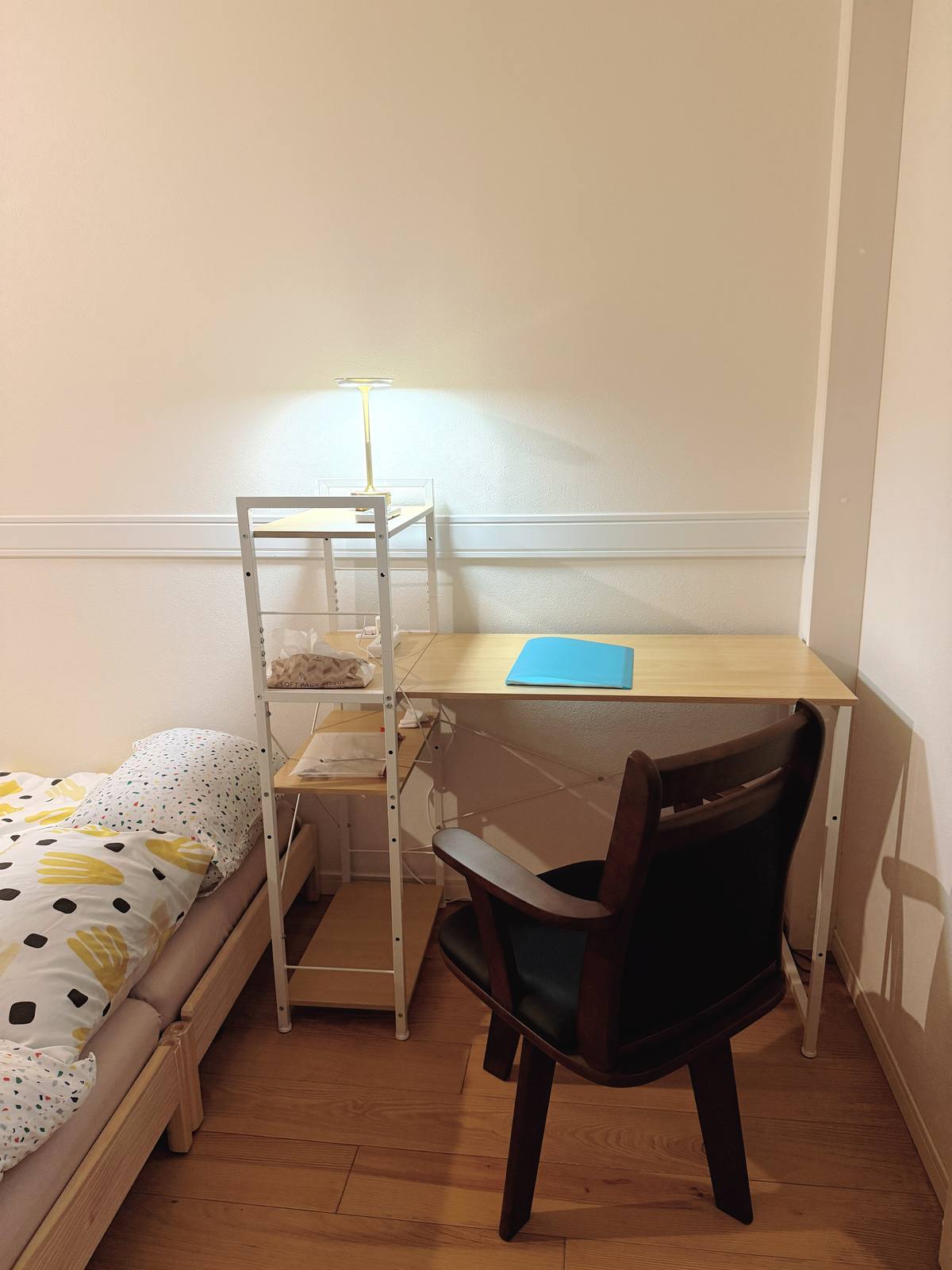 A tidy desk workspace beside the bed.